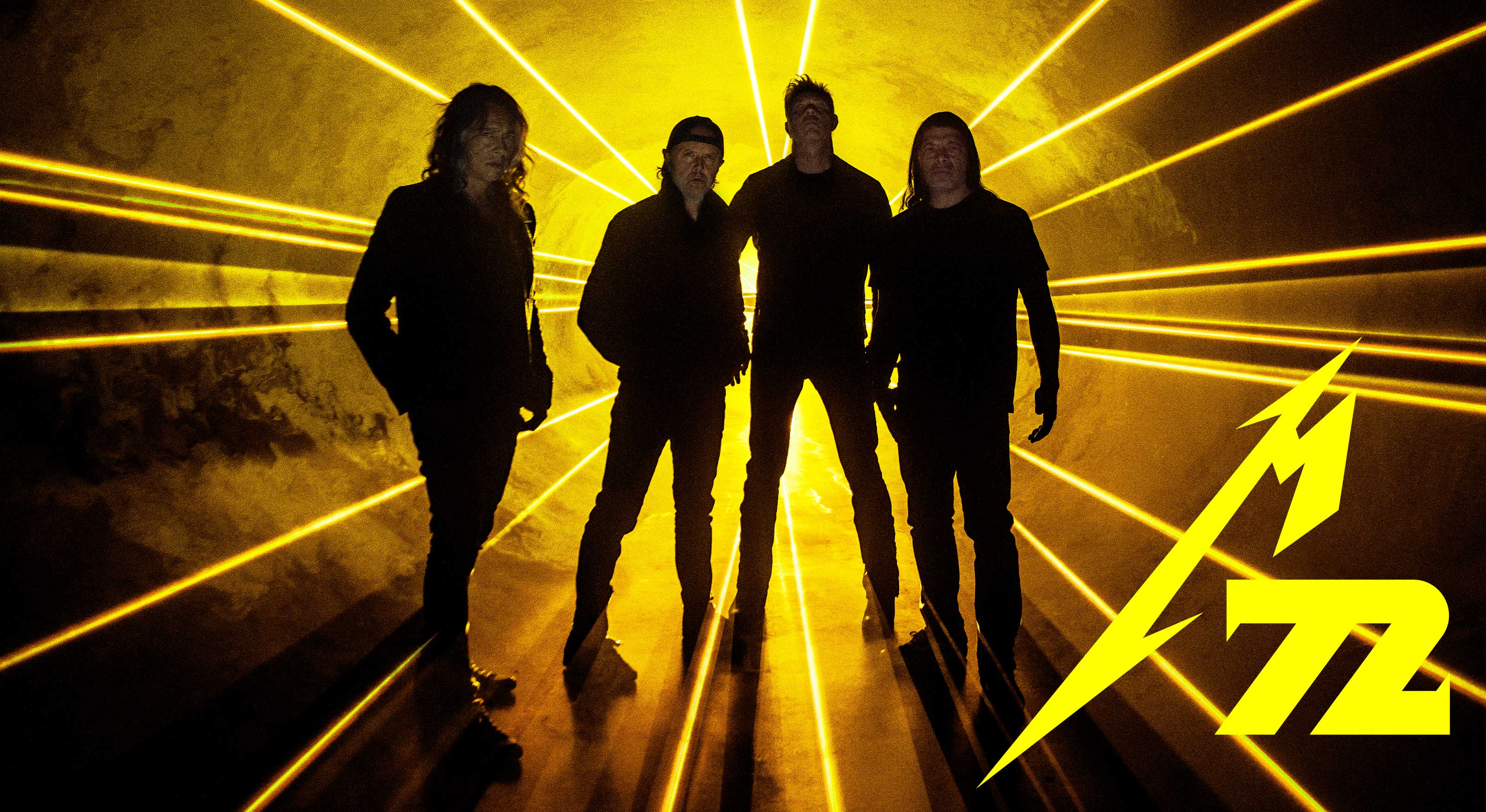 Silhouette of band members in a yellow, laser light tunnel. The bottom-right corner reads "M72".